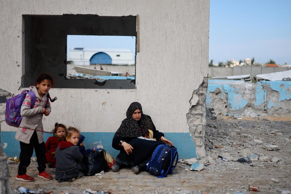 A woman rests with children, as Palestinian arrive in Rafah after they were evacuated from Nasser hospital in Khan Younis due to the Israeli ground operation (REUTERS)