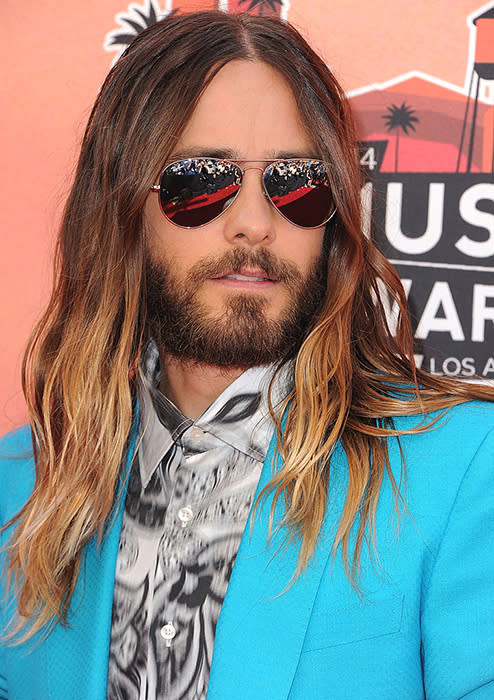 Les règles d’or du style Jared Leto : un costume, oui, mais jamais classique, une chemise bariolée et des lunettes si possible de type aviator. Et ça marche à tous les coups ! Sans parler de sa longue chevelure avec coloration tie and dye qui lui apporte encore plus de charme.