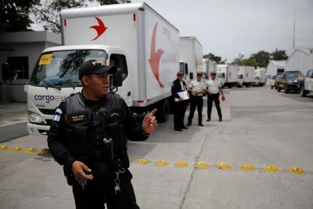Guatemalan Civil National Police officers secure a convoy with voting materials, to be distributed at a warehouse ahead of the second round run-off vote, in Guatemala City