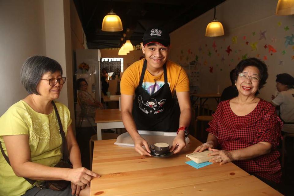 Danny serving customers at Tender Hearts, with a big smile on his face too. — Picture by Choo Choy May