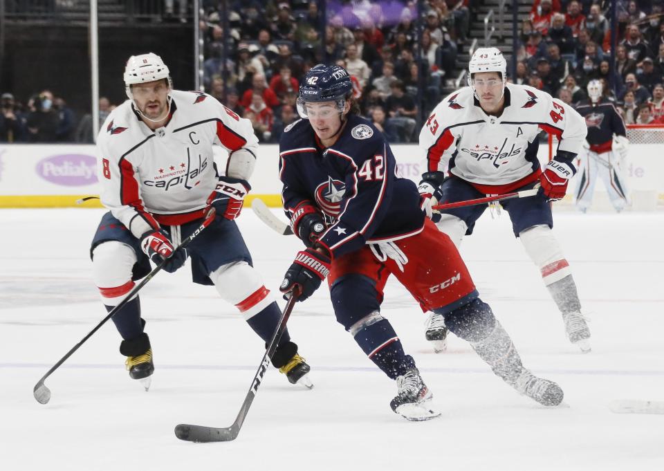 Columbus Blue Jackets center Alexandre Texier (42) brings the puck up ice ahead of Washington Capitals left wing Alex Ovechkin (8) and \w43#@\ during the third period of the NHL game at Nationwide Arena in Columbus on Friday, Nov. 12, 2021. The Capitals won 4-3.