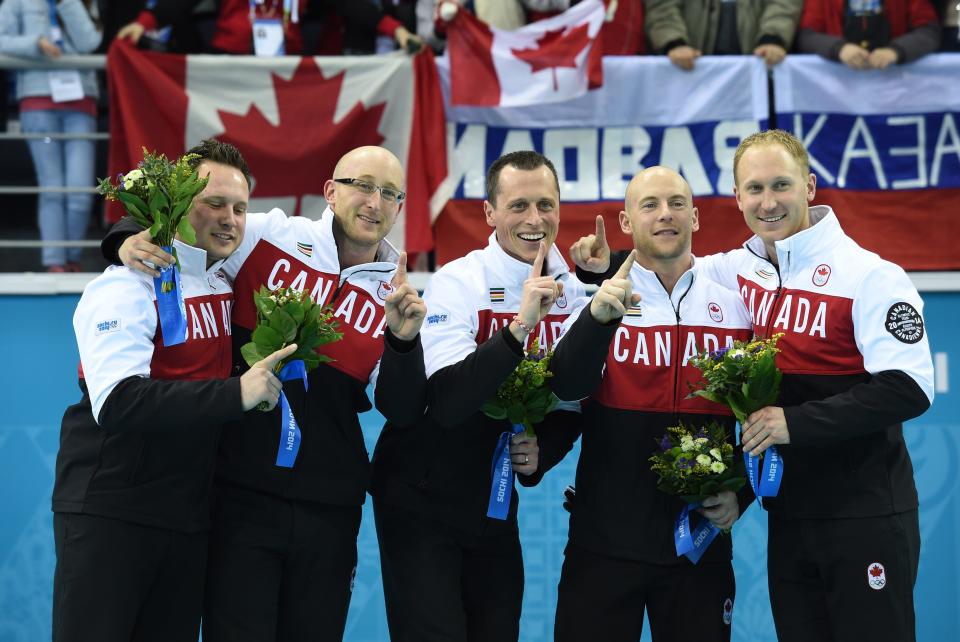 (L-R) Canada's gold medallists Caleb Flaxey, Ryan Harnden, E.J. Harnden, Ryan Fry and Brad Jacobs celebrate during the Men's Curling Flower Ceremony at the Ice Cube Curling Center in Sochi during the Sochi Winter Olympics on February 21, 2014. AFP PHOTO / LEON NEAL        (Photo credit should read LEON NEAL/AFP/Getty Images)