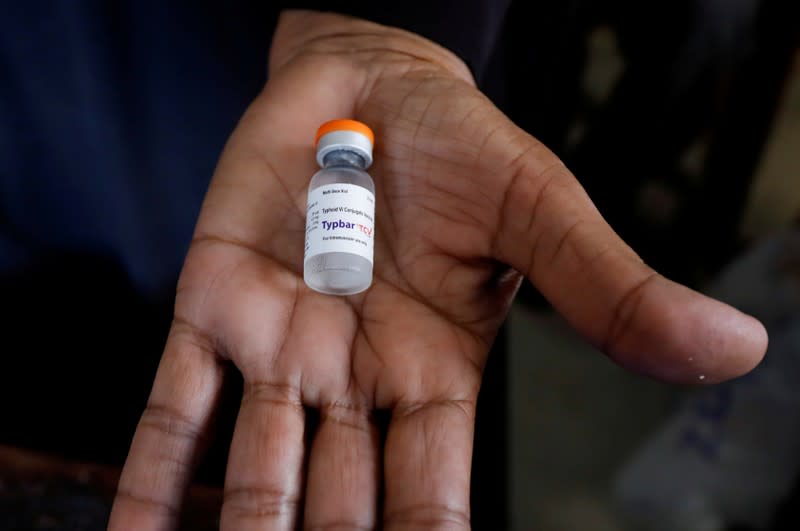 FILE PHOTO: A medical staff member holds a bottle of anti-typhoid vaccine to be given to children during the immunisation campaign at a school in Karachi