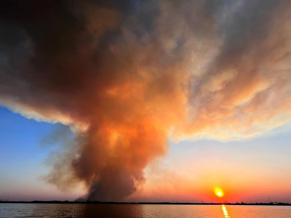 A view of the Mesquite Heat wildfire, illuminated by the setting sun, from Kirby Lake at sunset Wednesday.