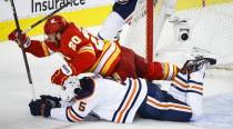 Edmonton Oilers defenseman Cody Ceci, bottom, and Calgary Flames forward Blake Coleman collide during the third period of Game 5 of an NHL hockey second-round playoff series Thursday, May 26, 2022, in Calgary, Alberta. (Jeff McIntosh/The Canadian Press via AP)