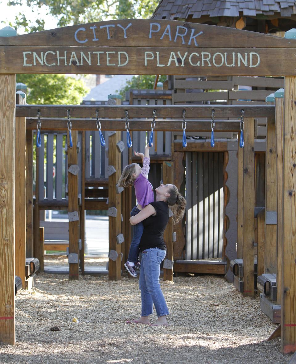 In this photo taken July 17, 2012, the park goers are seen at the Enchanted Playground at the Washington Playground park in Vallejo, Calif. In 2008 Vallejo filed for bankruptcy forcing cuts to many essential services and eliminated funding for a museum, symphony and senior center and slashed library spending. To fill the gaps citizens have stepped in with recreation programs, community gardens. In the seediest part of town, nearly 2,000 volunteers gathered to build the playground.(AP Photo/Rich Pedroncelli)