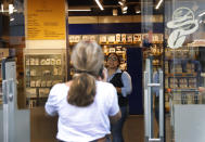 An employee turns away a customer at an international fashion and homeware retailer that will temporarily shut down from Friday in the face of an increasingly volatile currency market and their inability to set prices while the Lebanese pound plunges against the dollar, in Beirut, Lebanon, Thursday July 2, 2020. Later in the day, owners of the businesses rallied in central Beirut to denounce the government's inability to handle a deepening economic and financial crisis, and urging others to join them after the Lebanese pound recorded a new low Thursday, selling at nearly 10,000 for a dollar and maintaining the downward slide that saw the national currency lose about 85% of its value over the past months. (AP Photo/Hussein Malla)