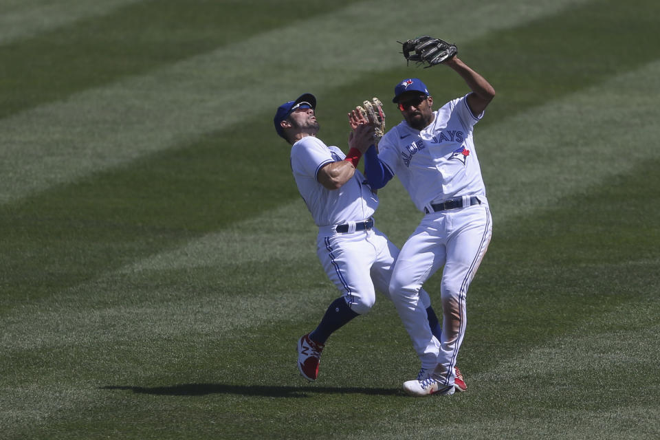 Toronto Blue Jays second baseman Marcus Semien, right, collides with center fielder Randal Grichuk, left, while making a catch during the seventh inning of a baseball game against the Houston Astros in Buffalo, N.Y., Sunday, June 6, 2021. (AP Photo/Joshua Bessex)