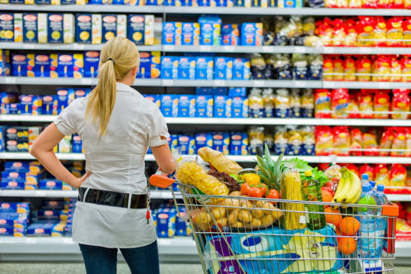 a woman is overwhelmed with the wide range in the supermarket when shopping.