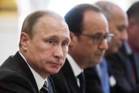 Russian President Vladimir Putin (L) and French President Francois Hollande sit together at the start of a summit on Ukraine at the Elysee Palace in Paris, France, October 2, 2015. REUTERS/Etienne Laurent/Pool