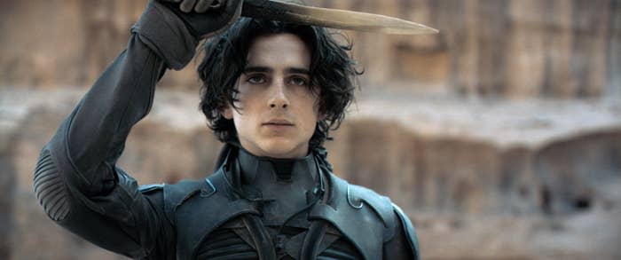 Timothée Chalamet as Paul Atreides wearing a stillsuit with a dagger in hand from the film "Dune."