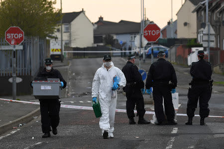 FILE PHOTO: Police officers carry a box of evidence as they leave the scene where the 29-year-old journalist Lyra McKee was shot dead, in Londonderry, Northern Ireland April 19, 2019. REUTERS/Clodagh Kilcoyne/File Photo