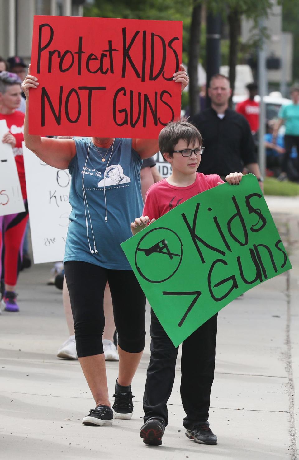 Bernadette Keele and her grandson Jack Miller, 9, of Akron, hold signs as they take part in the Walk for Our Lives Wednesday in Akron.