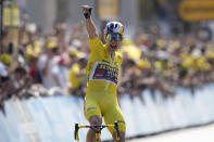 Belgium's Wout Van Aert, wearing the overall leader's yellow jersey celebrates as he crosses the finish line to win the fourth stage of the Tour de France cycling race over 171.5 kilometers (106.6 miles) with start in Dunkerque and finish in Calais, France, Tuesday, July 5, 2022. (AP Photo/Thibault Camus)