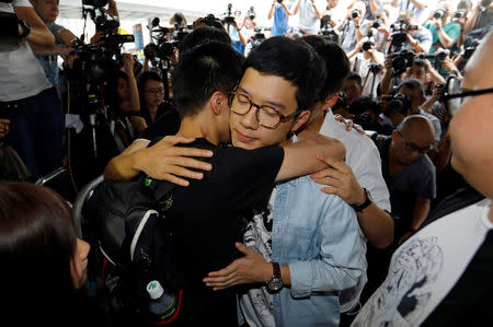 Student leaders Nathan Law and Joshua Wong hug Lester Shum as they arrive at the High Court to face verdict on charges relating to the 2014 pro-democracy Umbrella Movement, also known as Occupy Central protests, in Hong Kong, China August 17, 2017. REUTERS/Tyrone Siu