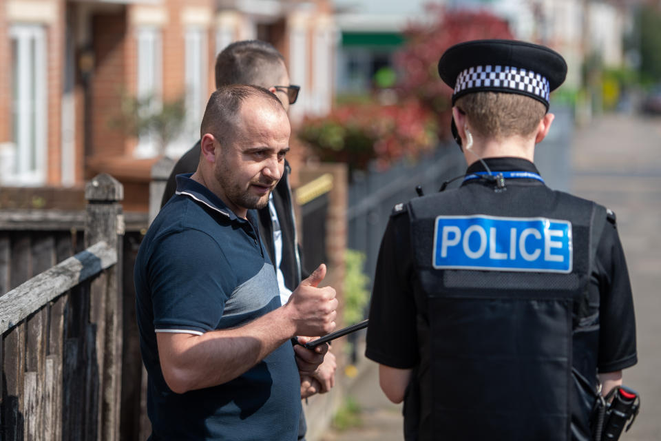 A police officer talks to members of the public about adhering to social distancing guidelines in Northampton, as Northants Police announce they are toughening up their social distancing enforcement, as the UK continues in lockdown to help curb the spread of Covid-19.