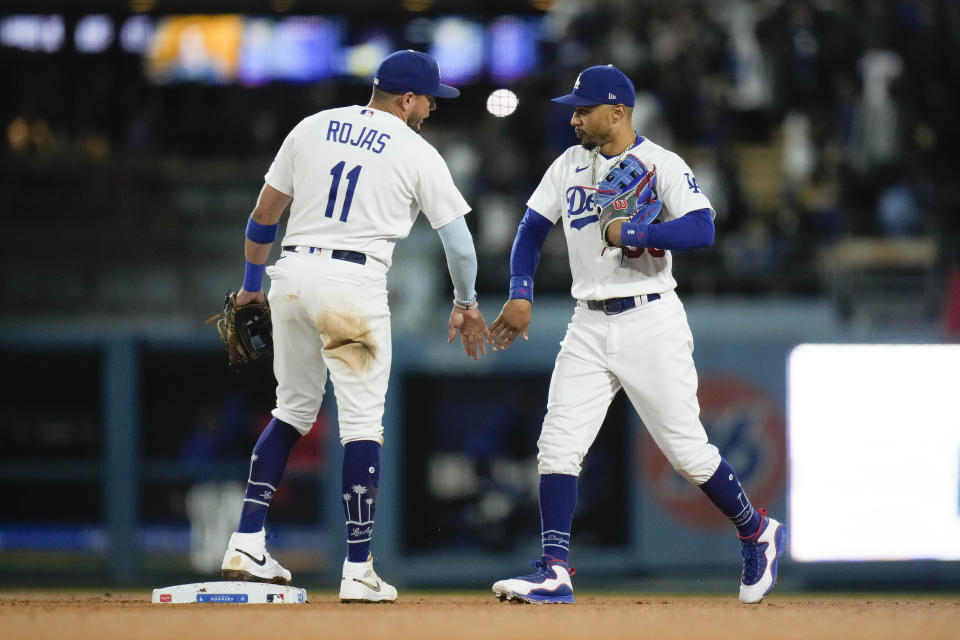 Los Angeles Dodgers' Miguel Rojas (11) and Mookie Betts celebrate the team's win against the Houston Astros in a baseball game Friday, June 23, 2023, in Los Angeles. (AP Photo/Jae C. Hong)