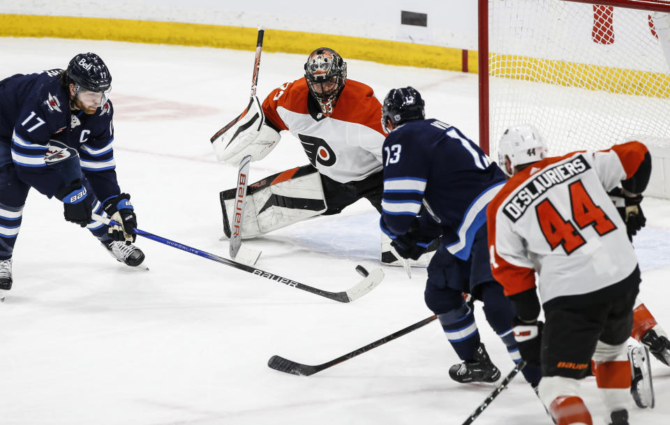 Philadelphia Flyers goaltender Samuel Ersson (33) saves a shot by Winnipeg Jets' Gabriel Vilardi (13) during second-period NHL hockey game action in Winnipeg, Manitoba, Saturday, Jan. 13, 2024. (John Woods/The Canadian Press via AP)