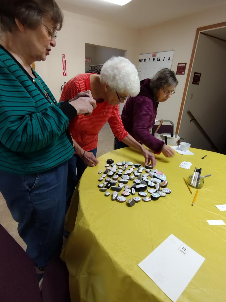 Nu Alpha Gamma Chapter members decorate kindness rocks at their May 6 chapter meeting.
