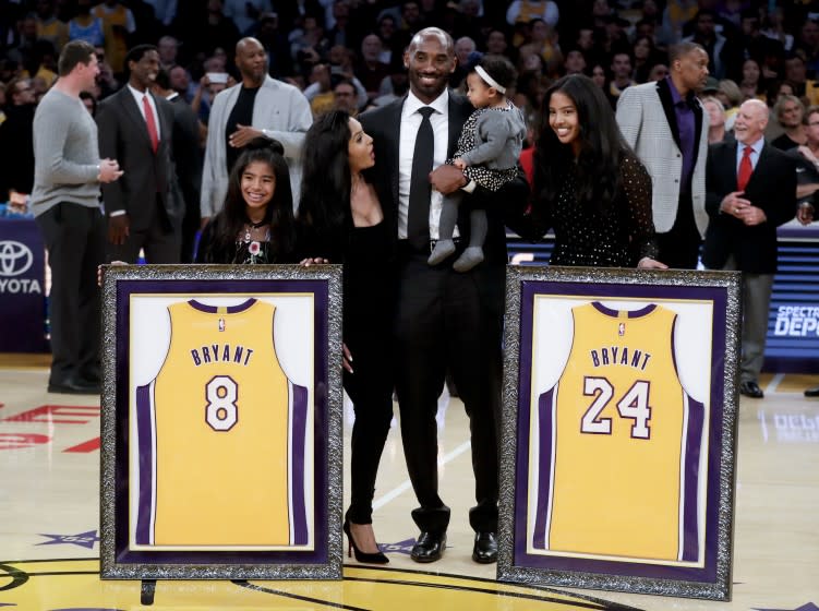 Kobe Bryant poses with his family after getting his jerseys retired before a game between the Lakers and the Golden State Warriors at Staples Center on Dec. 18, 2017.