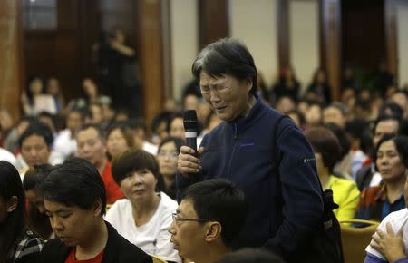 A relative of five passengers who were on board Malaysia Airlines flight MH370 cries before she speaks to Malaysian representatives during a briefing at Lido Hotel in Beijing April 21, 2014. REUTERS/Jason Lee