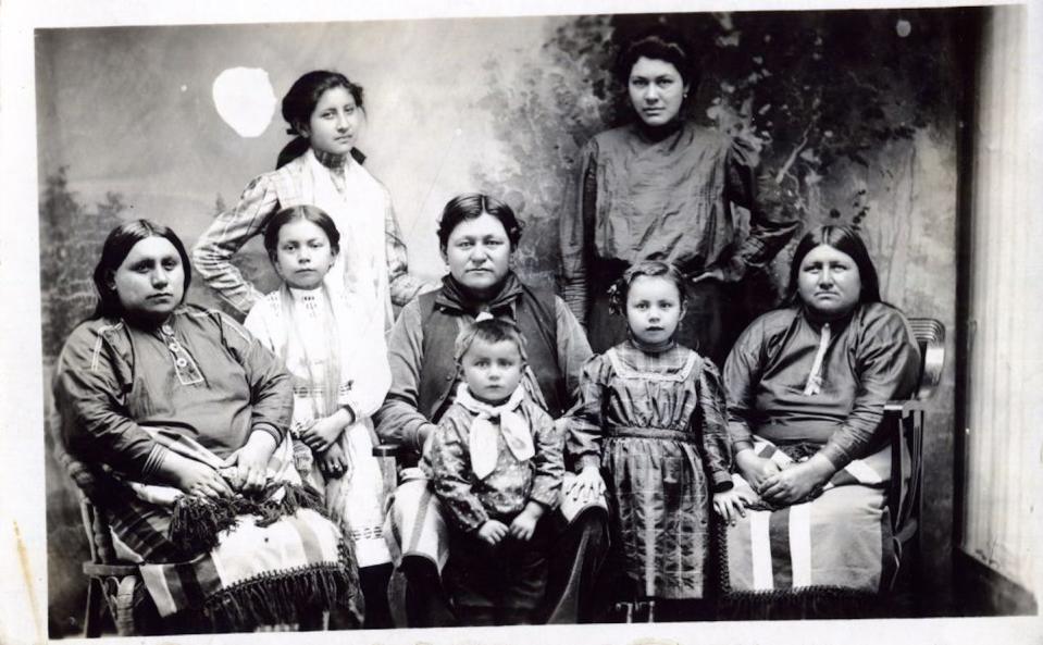 Eight women and girls, young and old, pose for a group photograph.