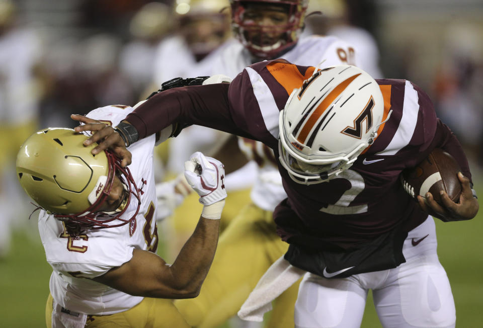 Virginia Tech quarterback Hendon Hooker, right, stiff arms Deon Jones, left, of Boston College in the first half of an NCAA college football game in Blacksburg, Va. Saturday, Oct. 17, 2020. (Matt Gentry/The Roanoke Times via AP, Pool)