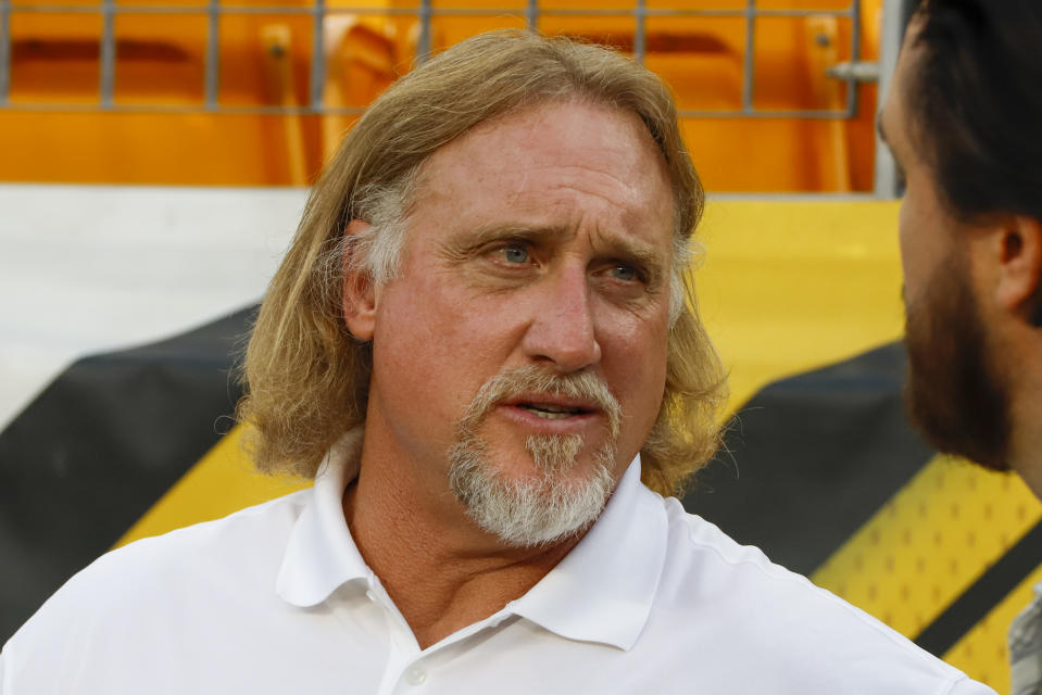 FILE - In this Sept. 30, 2019, file photo, Pro Football Hall of Fame outside linebacker Kevin Greene stands on the sideline during warmups before an NFL football game between the Pittsburgh Steelers and the Cincinnati Bengals in Pittsburgh. Hall of Fame linebacker Greene, considered one of the fiercest pass rushers in NFL history, has died. He was 58. Greene died Monday, Dec. 21, 2020, the family confirmed, as did the Pro Football Hall of Fame. (AP Photo/Gene J. Puskar, File)