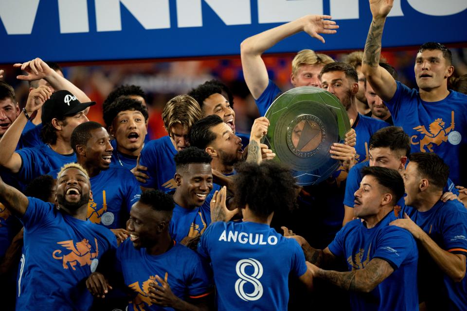 FC Cincinnati midfielder Luciano Acosta (10) holds up the Supporters' Shield with other members of the team during a ceremony following the MLS match between FC Cincinnati and New York Red Bulls at TQL Stadium in Cincinnati on Wednesday, Oct. 4, 2023.