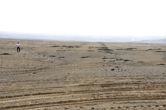 A view of two rock lines that mark the June solstice with a person for scale.