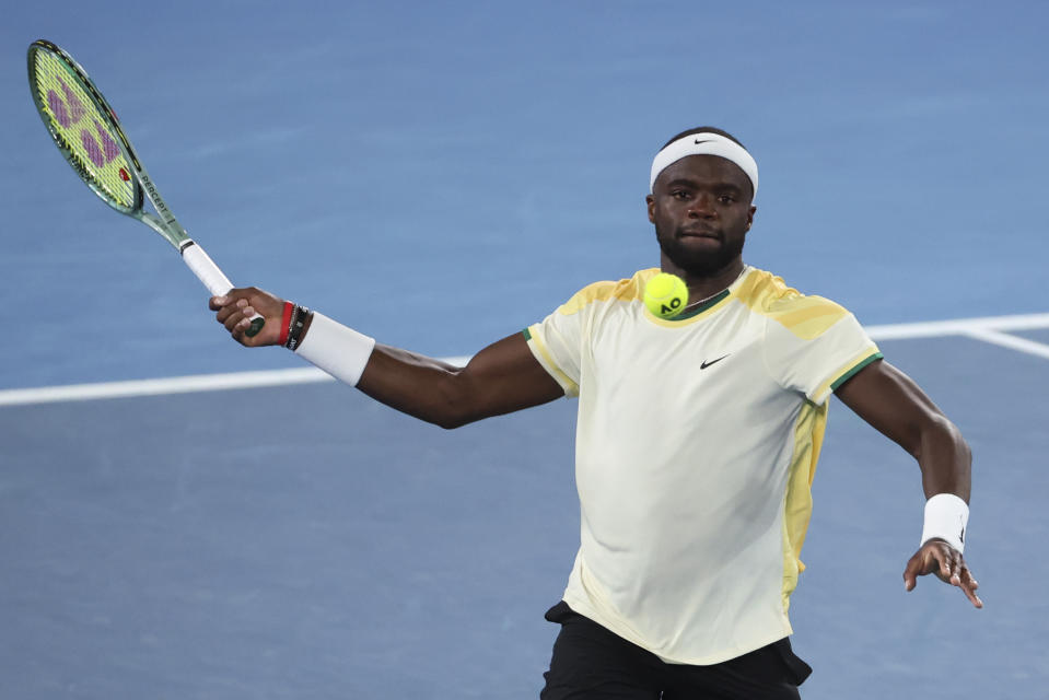 Frances Tiafoe of the U.S. plays a forehand return to Borna Coric of Croatia during their first round match at the Australian Open tennis championships at Melbourne Park, Melbourne, Australia, Sunday, Jan. 14, 2024. (AP Photo/Asanka Brendon Ratnayake)