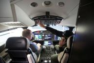 Employees make last minute adjustments in the cockpit of Bombardier's Global 7500, the first business jet to have a queen-sized bed and hot shower, shown during a media tour in Montreal