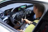 Visitor sits inside a Mercedes Benz vehicle with a car racing game on the screen, at the CES Asia exhibition in Shanghai
