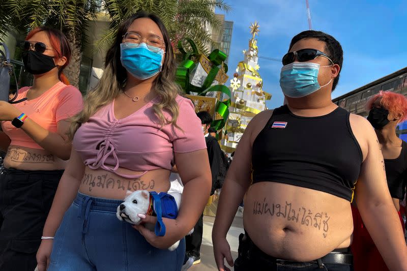 Protest leaders Panusaya "Rung" Sithijirawattanakul and Parit "Penguin" Chiwarak wearing crop tops walk at Siam Paragon shopping centre, as they demonstrate against the monarchy, in Bangkok