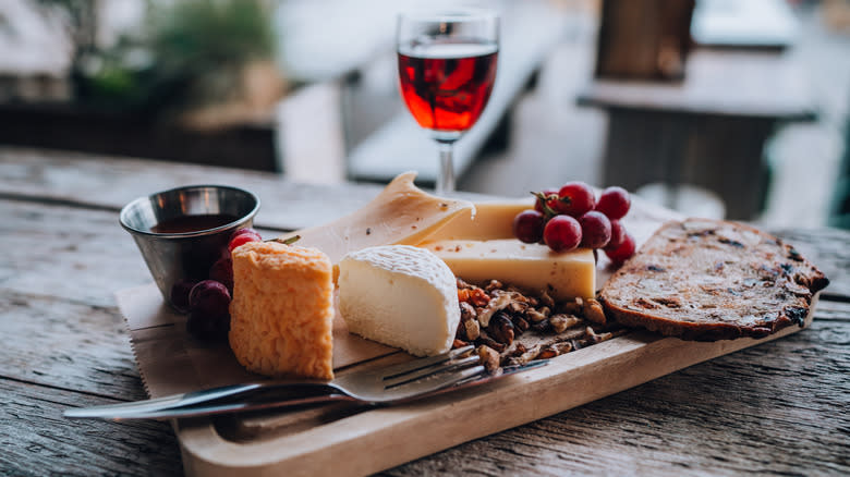 Glass of red port wine beside a charcuterie board