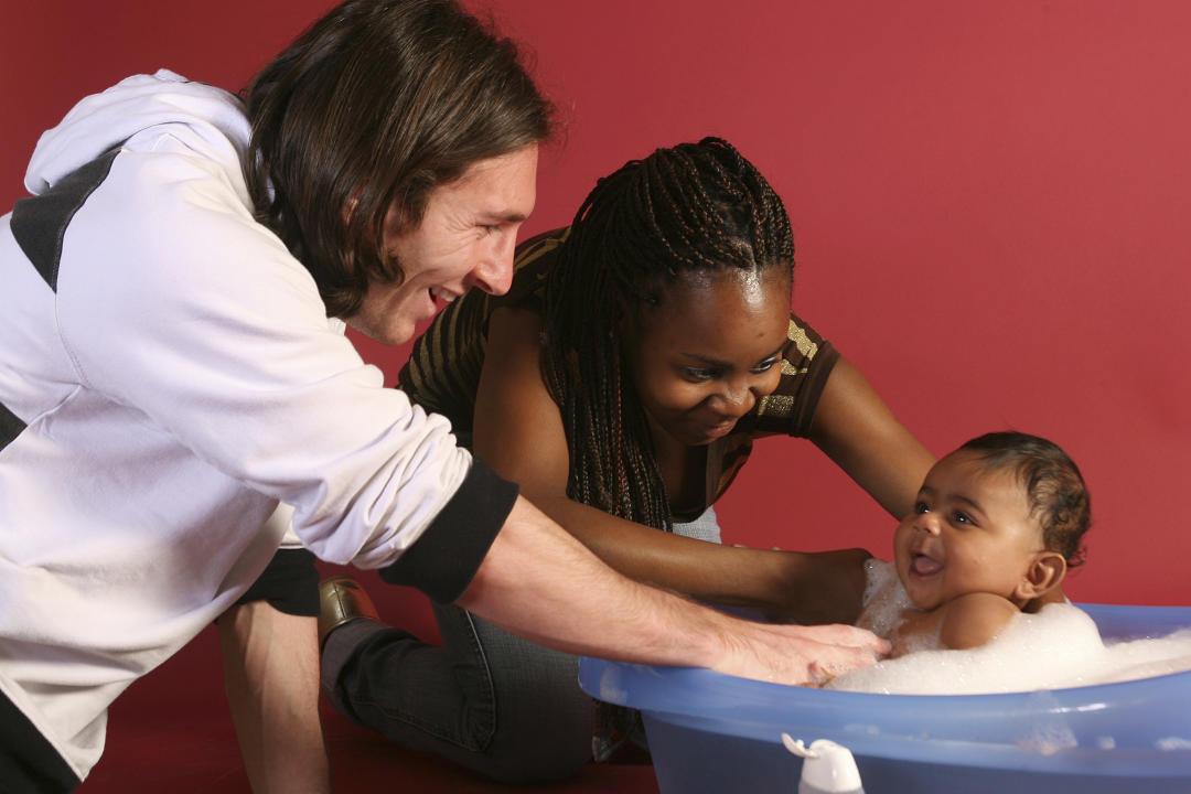 This photo taken in Sept. 2007 shows a 20-year-old Lionel Messi, who had embarked on his legendary Barcelona career just over four years prior, helping to bathe Lamine Yamal, who was merely six months old at the time with Yamal's mother Sheila Ebana, during a photo session in the dressing room of the Camp Nou stadium in Barcelona, Spain. Lamine Yamal is now a soccer sensation for both Spain and Barcelona and he is still only 16-years-old. (AP Photo/Joan Monfort)