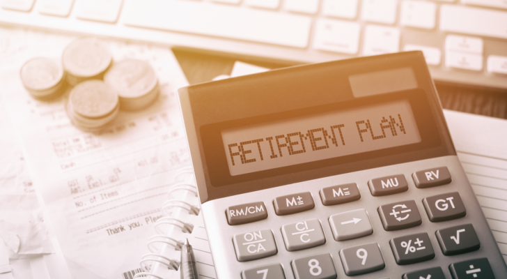 Coins stacked next to a calculator that says "retirement plan." Retirement stocks.