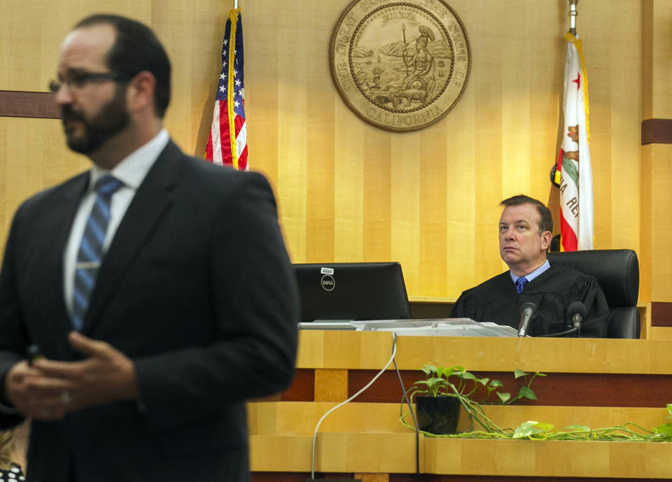 Judge Blaine Bowman, right, listens as Deputy District Attorney Dan Owens gives his opening statement to the jury on the opening day of former NFL football player Kellen Winslow Jr.'s rape trial, Monday, May 20, 2019, in Vista, Calif. (John Gibbins/The San Diego Union-Tribune via AP, Pool)