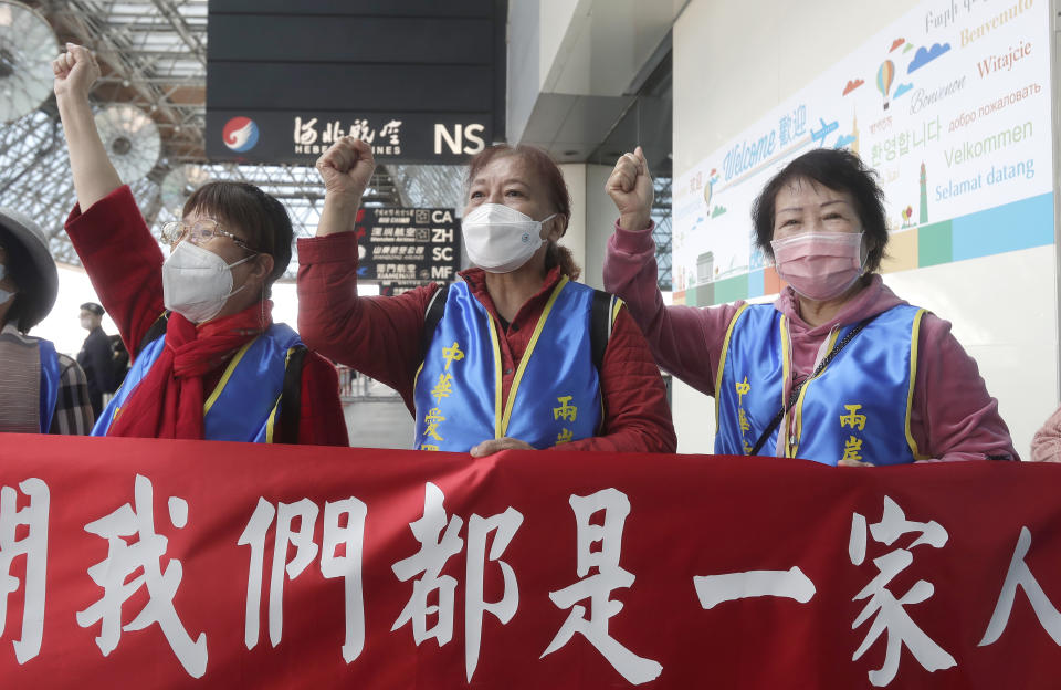 Supporters hold slogans reading ''We Are All One Family'', as former Taiwan President Ma Ying-jeou leaves for China, outside of Taoyuan International Airport in Taoyuan City, northern Taiwan, Monday, March 27, 2023. Ma is scheduled to visit China Monday on a 12-day tour, a day after Taiwan lost another one of its diplomatic allies to China. (AP Photo/Chiang Ying-ying)