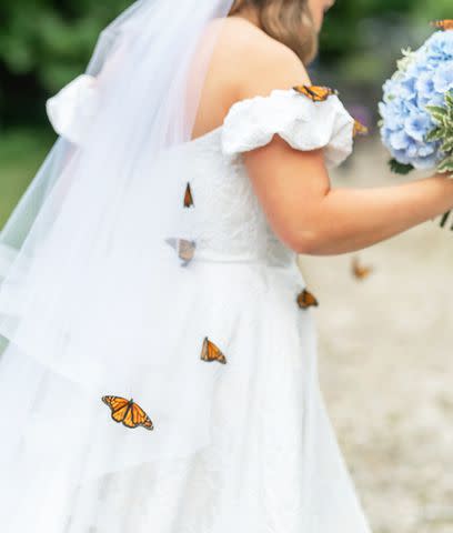 <p>Brit Perkins</p> Closeup of butterflies on Amy Rose Perry's wedding dress