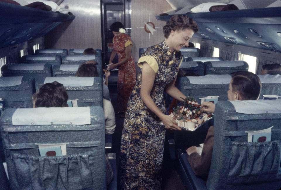 Flight attendants serve food and drinks to passengers on a Japan Airlines plane in 1958.