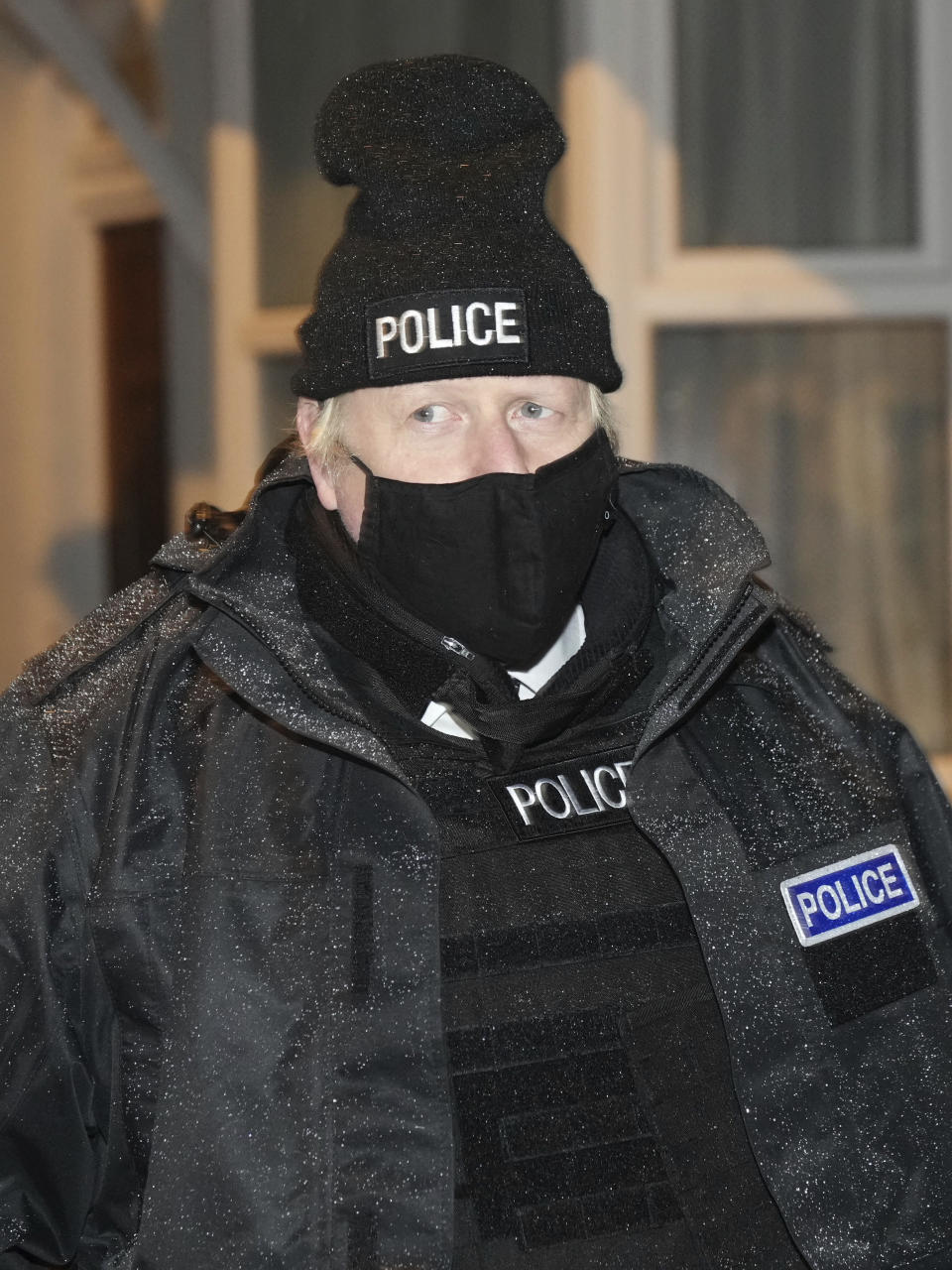 Britain's Prime Minister Boris Johnson observes an early morning police raid on a home in Liverpool, England, Monday Dec, 6, 2021, ahead of the publication of the government's 10-year drug strategy. (Christopher Furlong/Pool via AP)