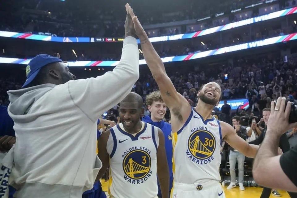 Golden State Warriors guard Stephen Curry (30) celebrates with guard Chris Paul (3) and Draymond Green, left, after the Warriors defeated the Sacramento Kings in an NBA preseason basketball game in San Francisco, Wednesday, Oct. 18, 2023. (AP Photo/Jeff Chiu)