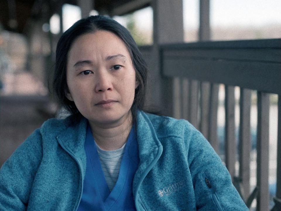 Hong Chau sits on a porch