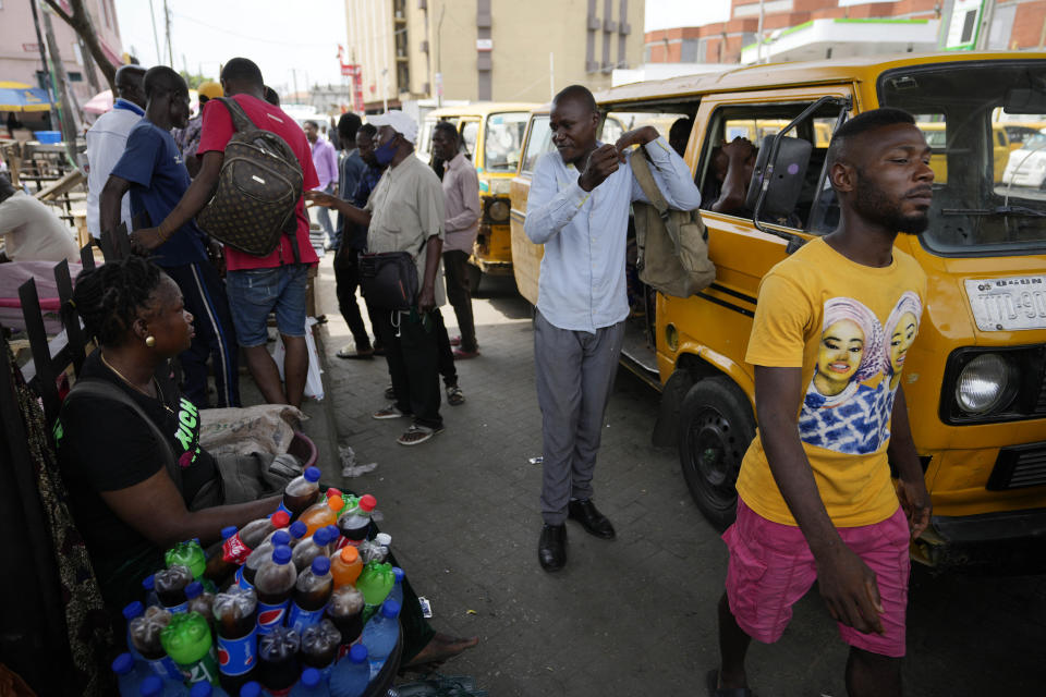 A woman sells soft drinks at a bus station in Lagos, Nigeria Monday, Feb. 27, 2023. Each of the three frontrunners in Nigeria's hotly contested presidential election claimed they were on the path to victory Monday, as preliminary results trickled in two days after Africa's most populous nation went to the polls. (AP Photo/Sunday Alamba)