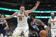 Denver Nuggets center Nikola Jokic (15) defends the drive by Dallas Mavericks guard Kyrie Irving (11) during the first half of an NBA basketball game in Dallas, Sunday, March 17, 2024. (AP Photo/LM Otero)