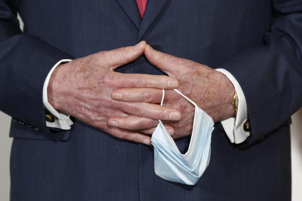 Senate Majority Leader Mitch McConnell of Ky., holds a face mask used to protect against the spread of the new coronavirus as he attends a press conference after meeting with Senate Republicans at their weekly luncheon on Capitol Hill in Washington, Tuesday, May 19, 2020. (AP Photo/Patrick Semansky)