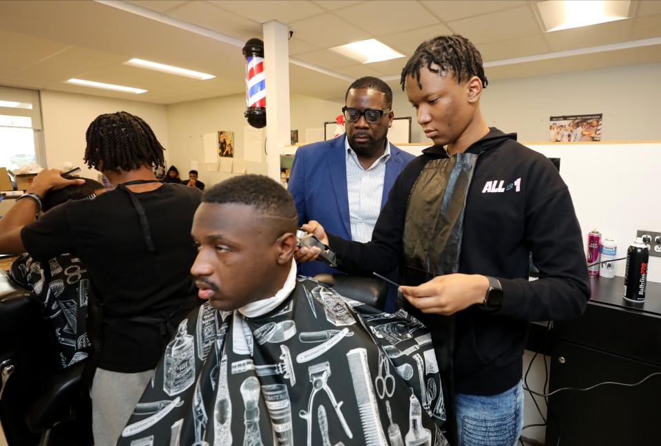 Rick Boreland, center, the instructor, looks over the work being done by 11th grade stylist Comarr Morgan and subject Jaden Nathan in the barbering class at Mount Vernon High School.