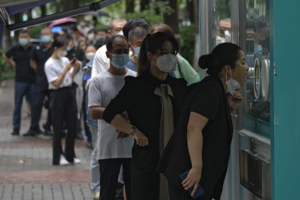Residents line up to get their routine COVID-19 throat swabs at a coronavirus testing site in Beijing, Tuesday, Aug. 9, 2022. Chinese authorities have closed Tibet's famed Potala Palace after a minor outbreak of COVID-19 was reported in the Himalayan region. (AP Photo/Andy Wong)