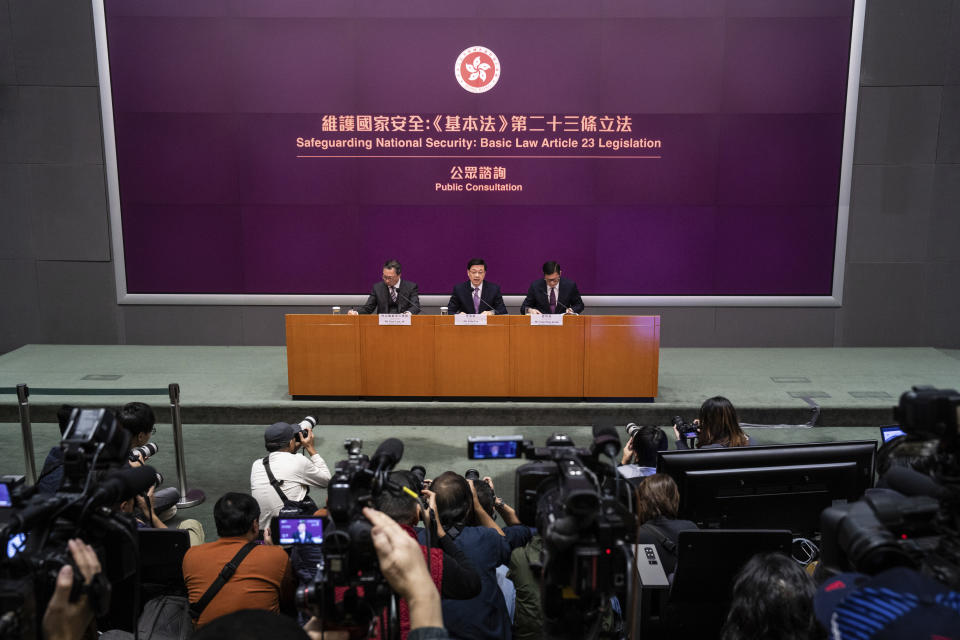 Hong Kong Chief Executive John Lee, center, Secretary for Justice Paul Lam, left, and Secretary for Security Chris Tang hold a press conference at government headquarters in Hong Kong, Tuesday, Jan. 30, 2024. (AP Photo/Louise Delmotte)